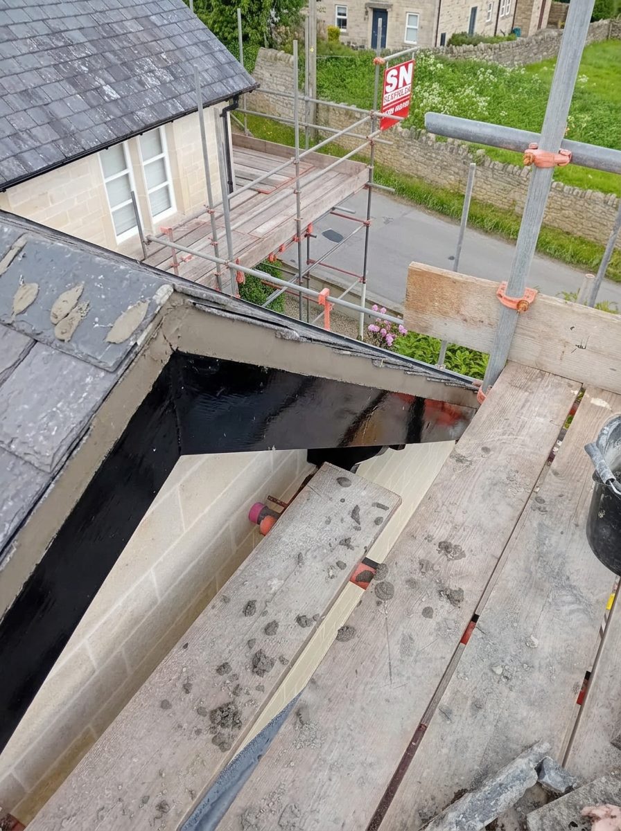 New black fascia boards and soffits below a slate roof edge